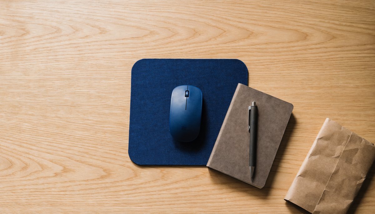 Tapis de souris, carnet et stylo présentés comme idées de cadeaux utiles pour le bureau