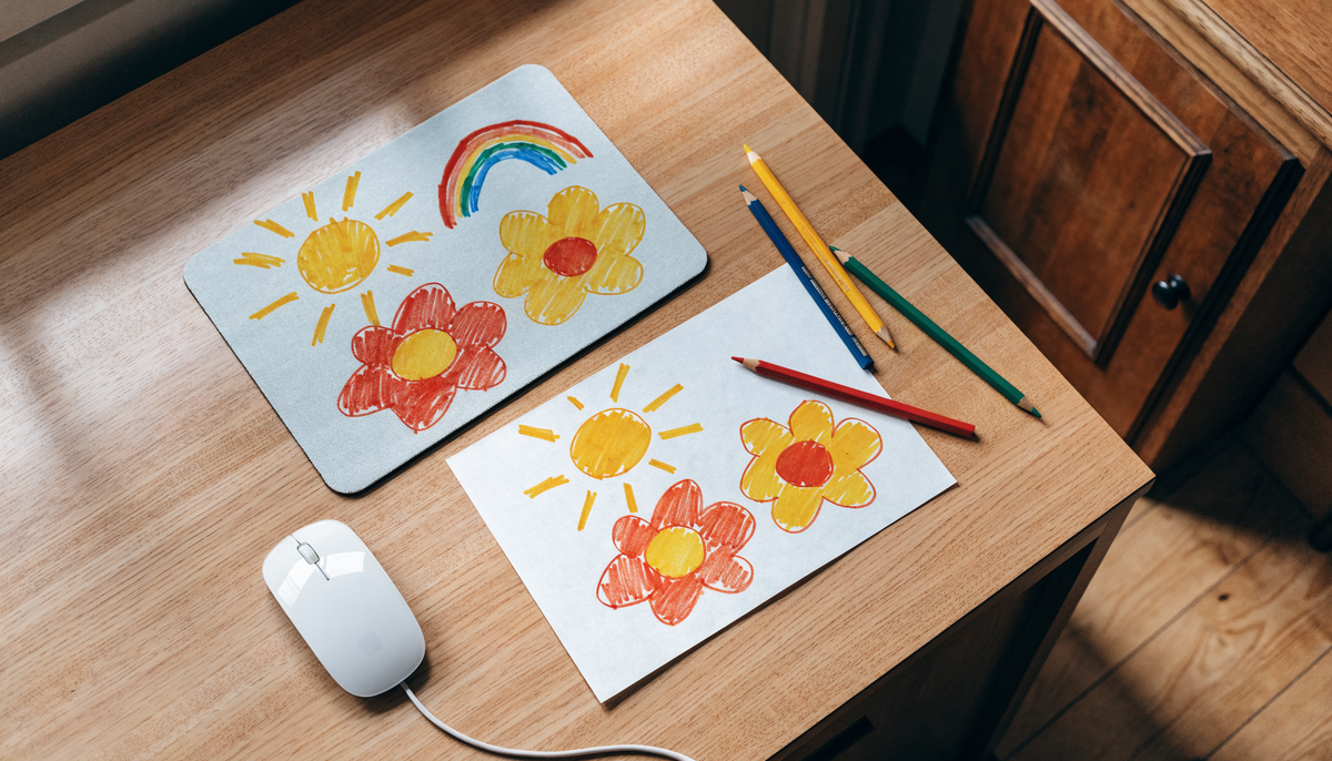 Dessin collectif coloré reproduit sur un tapis, entouré de crayons sur un bureau